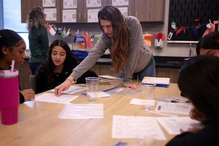 Teacher helping students at a table
